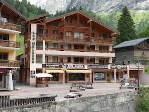 A multi-story wooden building with balconies, ski rental, and surf shops. - 2-room apartment - 6 guests - Pralognan (Pralognan-la-Vanoise)