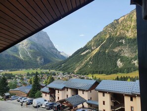 A mountain village with chalet-style buildings, a parking area, and a view of the surrounding mountains. - Apartment with stunning view - 6 guests (Pralognan-la-Vanoise)