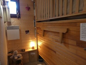 A wooden interior with a heater, a teddy bear, and a sign on the wall. - Renovated studio, mountain view - 4 guests (Pralognan-la-Vanoise)