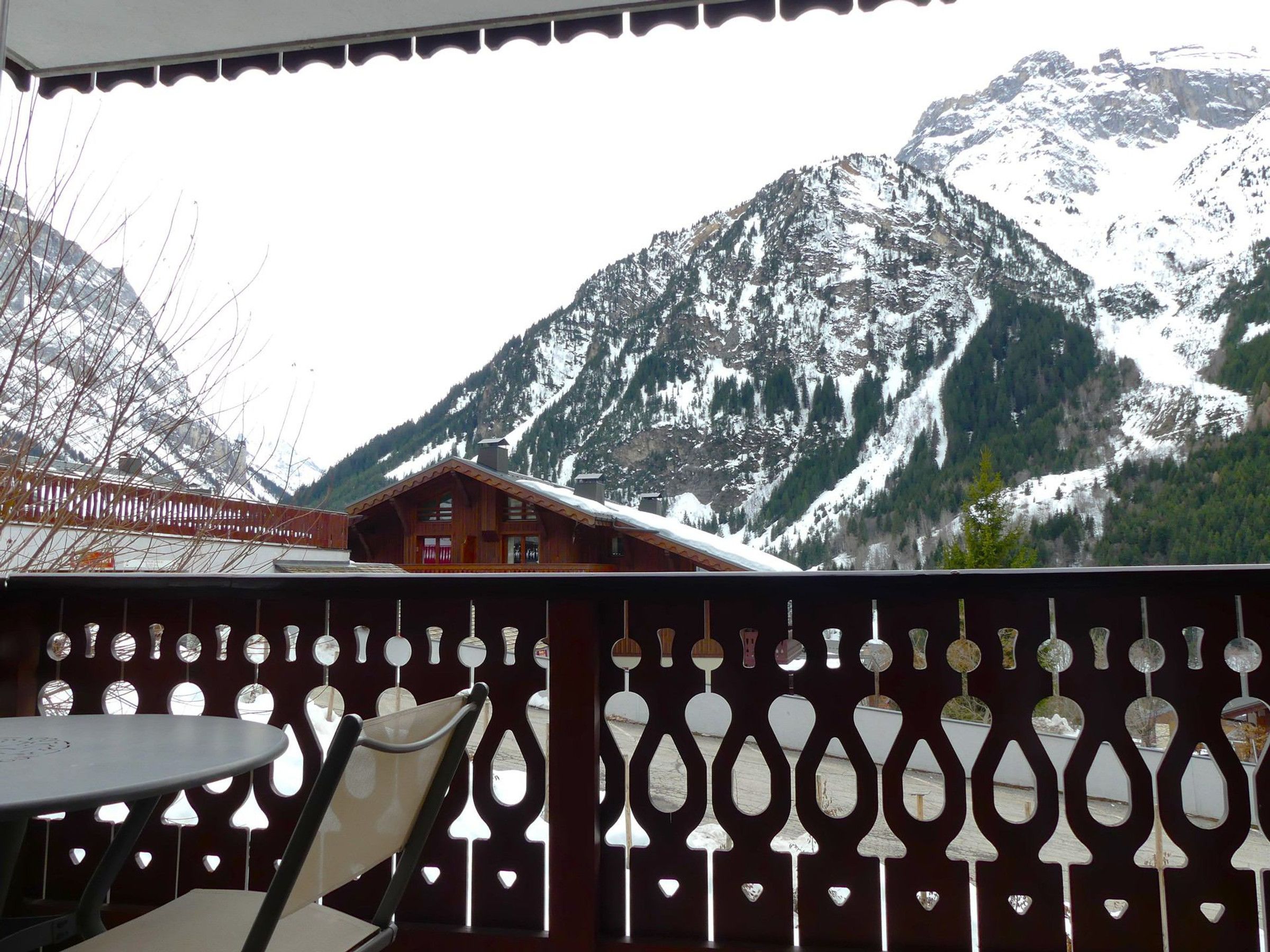 A wooden cabin with a snow-covered mountain backdrop.