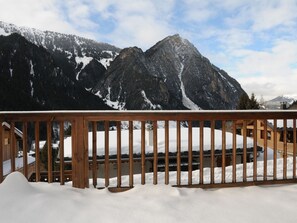 A wooden balcony with a view of snow-covered mountains and a clear sky. - Charming apartment - 7 guests (Pralognan-la-Vanoise)