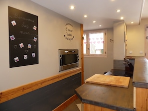 A kitchen with a blackboard, a microwave, and a wooden countertop. - Charming apartment - 7 guests (Pralognan-la-Vanoise)