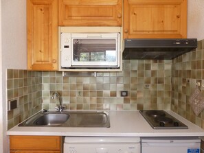 A kitchen with wooden cabinets, a microwave, a stove, and a dishwasher. - Studio-cabin with stunning view - 4 guests (Pralognan-la-Vanoise)