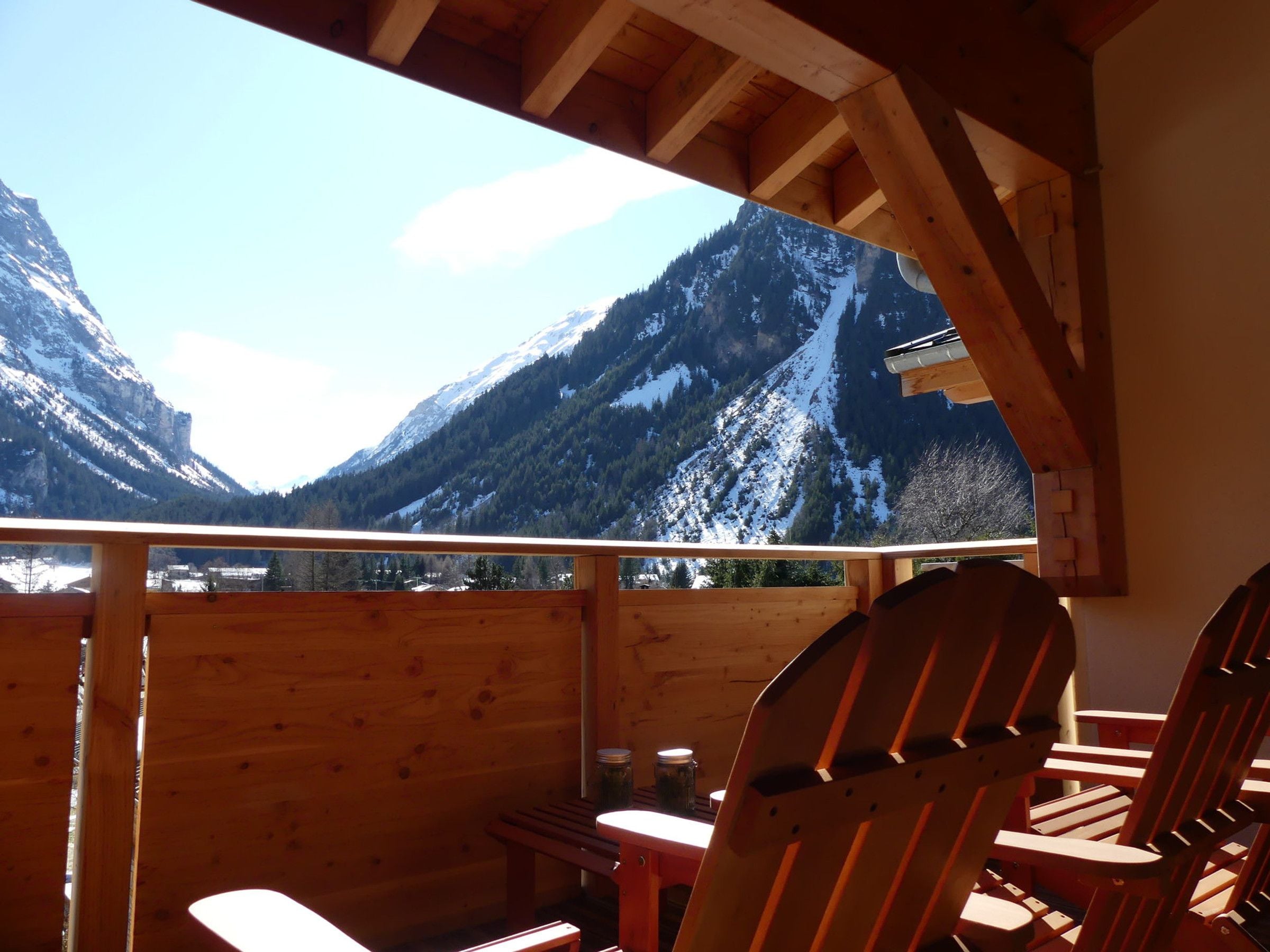 Une cabane en bois offrant une vue sur des montagnes enneigées.