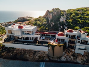 A coastal hotel with multiple buildings, a pool area, and a view of the sea. - Pedregal Villa with 75-ft Infiniti Pool + Panoramic Views (Cabo San Lucas)