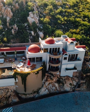A modern building with multiple balconies and a swimming pool. - Pedregal Villa with 75-ft Infiniti Pool + Panoramic Views (Cabo San Lucas)