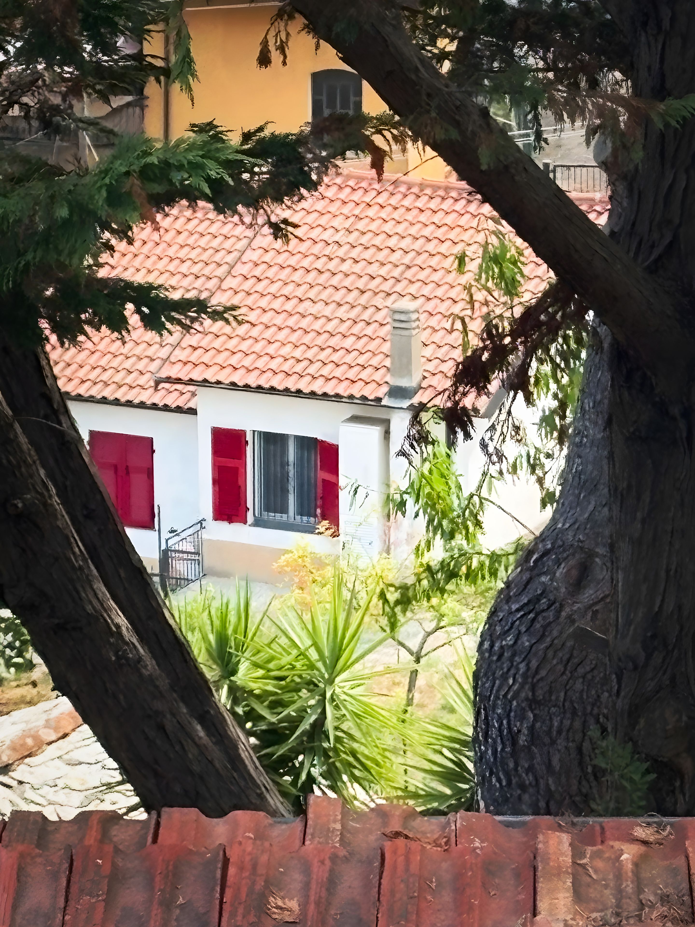 Ein Gebäude mit rotem Ziegeldach, weißen Wänden und roten Fensterläden.