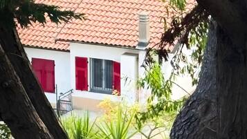 Ein Gebäude mit rotem Ziegeldach, weißen Wänden und roten Fensterläden.
