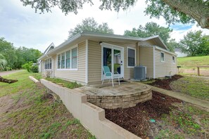A single-story house with a covered porch, a small outdoor seating area, and a landscaped yard. - 'tropical Hideaway' 3 Mi to Lake Louisa State Park (Clermont)