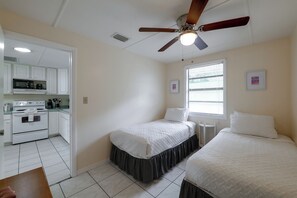 A compact bedroom with two beds, a kitchenette, and a ceiling fan. - 'tropical Hideaway' 3 Mi to Lake Louisa State Park (Clermont)