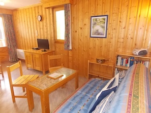 A wooden room with a bed, a desk with a computer, a chair, a bookshelf, and a window with curtains. - Cozy duplex close to all - 4/6 guests (Pralognan-la-Vanoise)