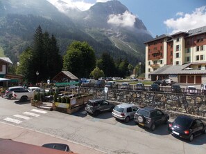 A parking area with cars, a stone wall, and a mountain backdrop. - Cozy duplex close to all - 4/6 guests (Pralognan-la-Vanoise)