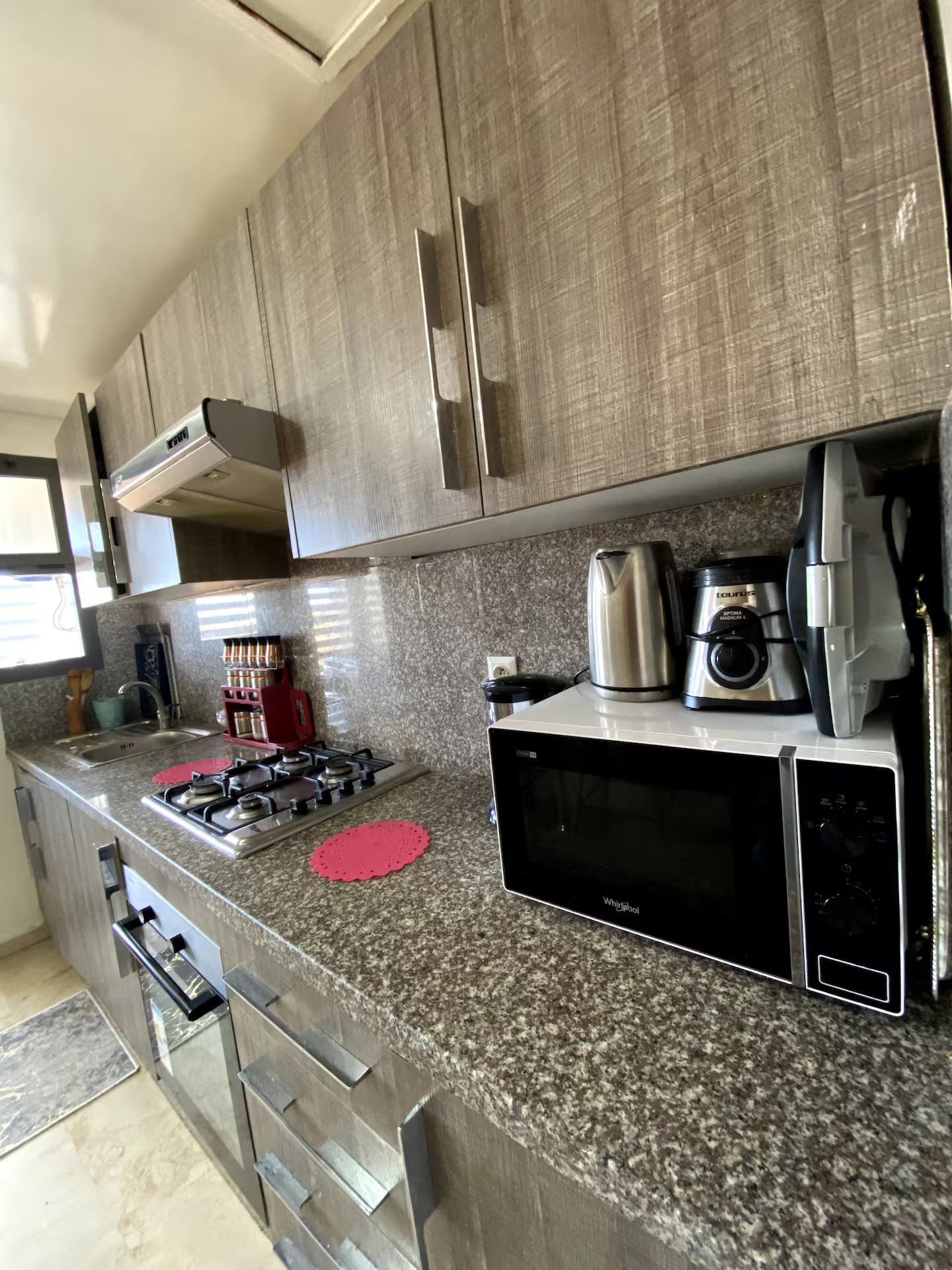 A modern kitchen with granite countertops, stainless steel appliances, and a gas stove.