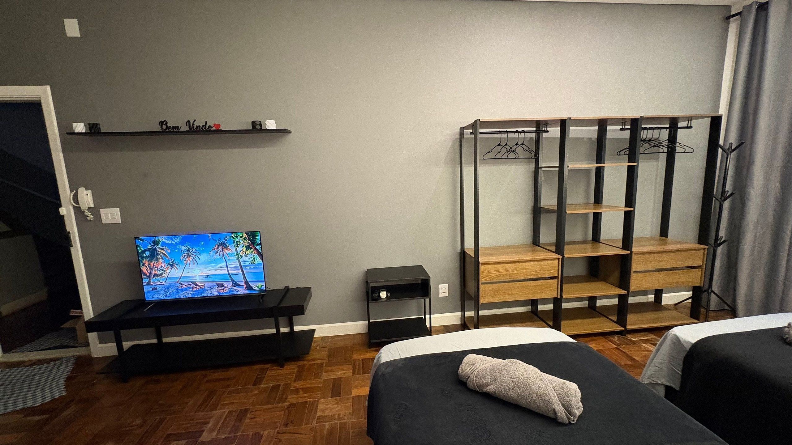 Une chambre équipée d’une télévision, d’une armoire et de deux lits.