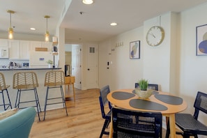 A modern kitchen with white cabinets, a built-in microwave, and a hanging light fixture. - Ocean-view Balcony! Myrtle Beach Resort Getaway (Myrtle Beach)