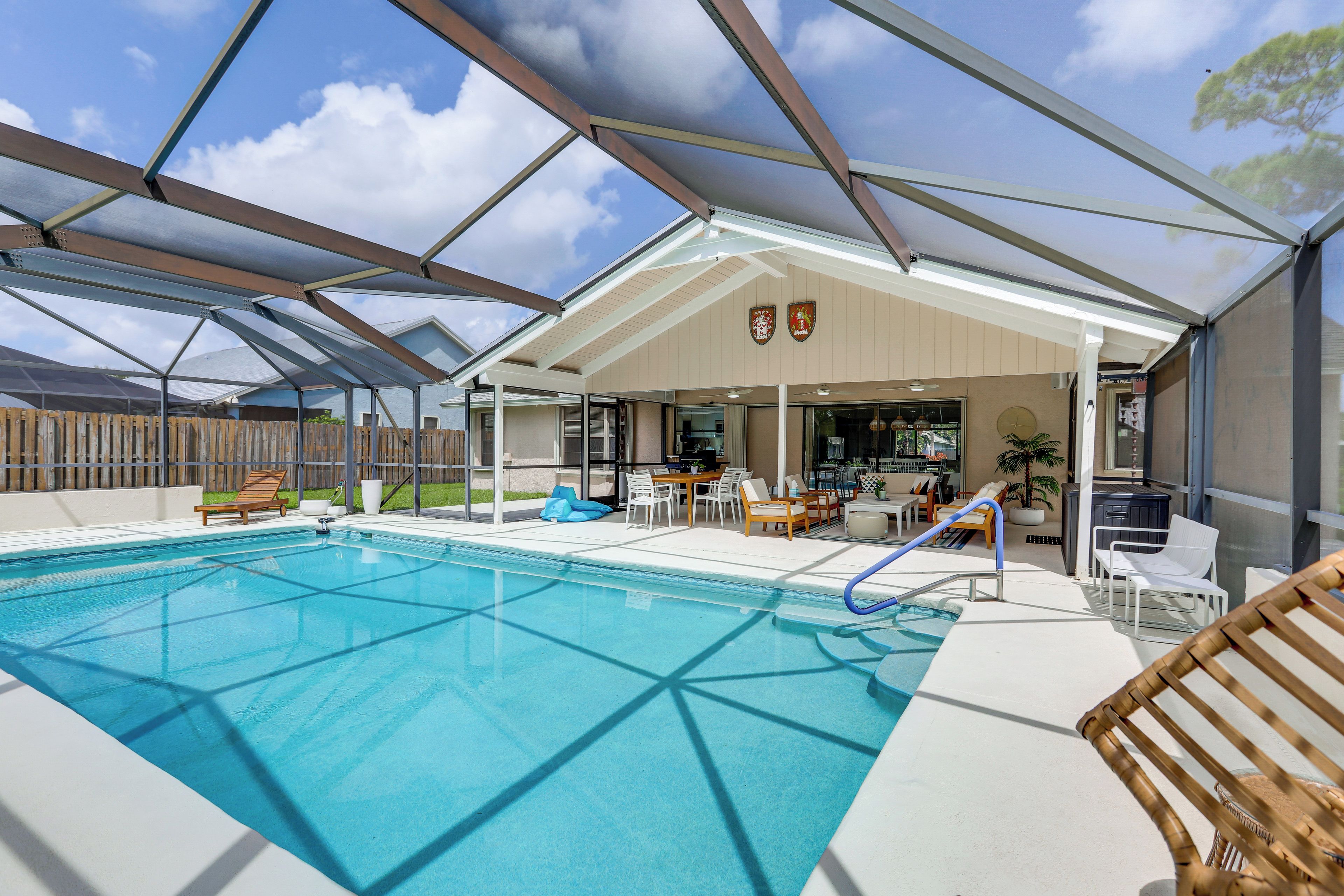 A covered outdoor swimming pool with lounge chairs and a patio area.