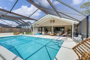 Ein überdachter Außenpool mit Liegestühlen und einer Terrasse.
