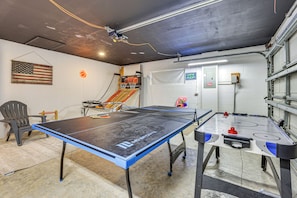 Sala de lazer com mesa de pingue-pongue, mesa de futebol de mesa e cesta de basquete.