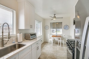 A modern kitchen with a built-in toaster, a stainless steel sink, and a gas stove. - Executive Oasis With In-suite Laundry Near Beach (Long Beach)