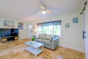 A living room with a sofa, coffee table, and a television.