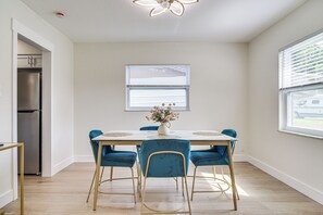 A modern kitchen with a built-in refrigerator, a dining table with blue chairs, and a window with blinds. - Fully Remodeled Brandon Escape w/ Fenced Yard! (Brandon)