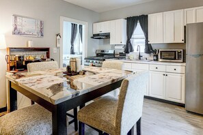 A modern kitchen with white cabinets, a stainless steel refrigerator, a microwave, and a stove. - 2-bedroom Bed & Breakfast in Adorable Lynn w/ A/C (Lynn)