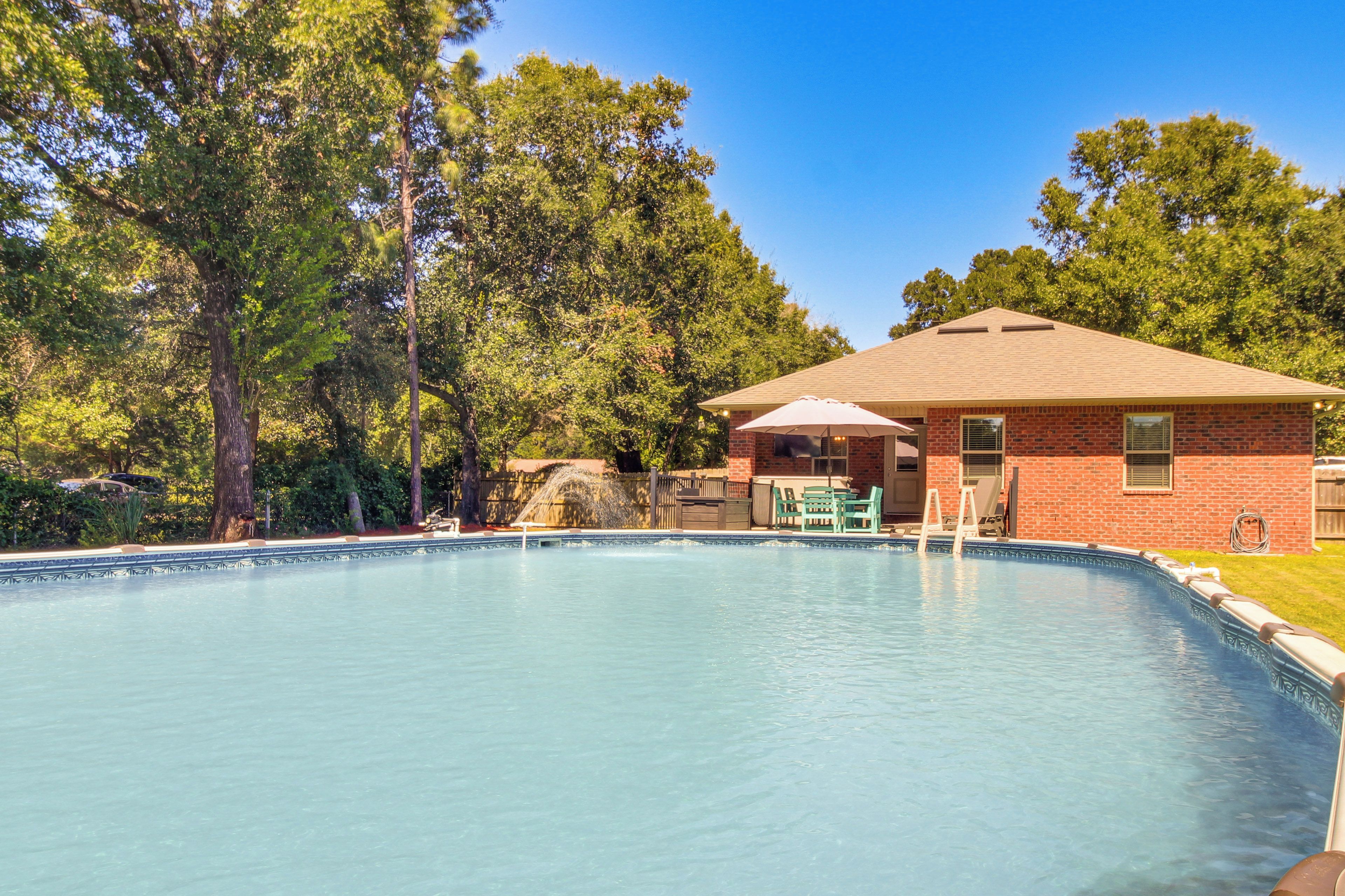A swimming pool with a brick building in the background.