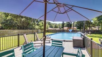 A wooden deck with a pool, surrounded by a wooden fence and trees.