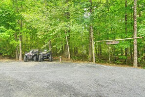 A gravel parking area with two off-road vehicles parked.