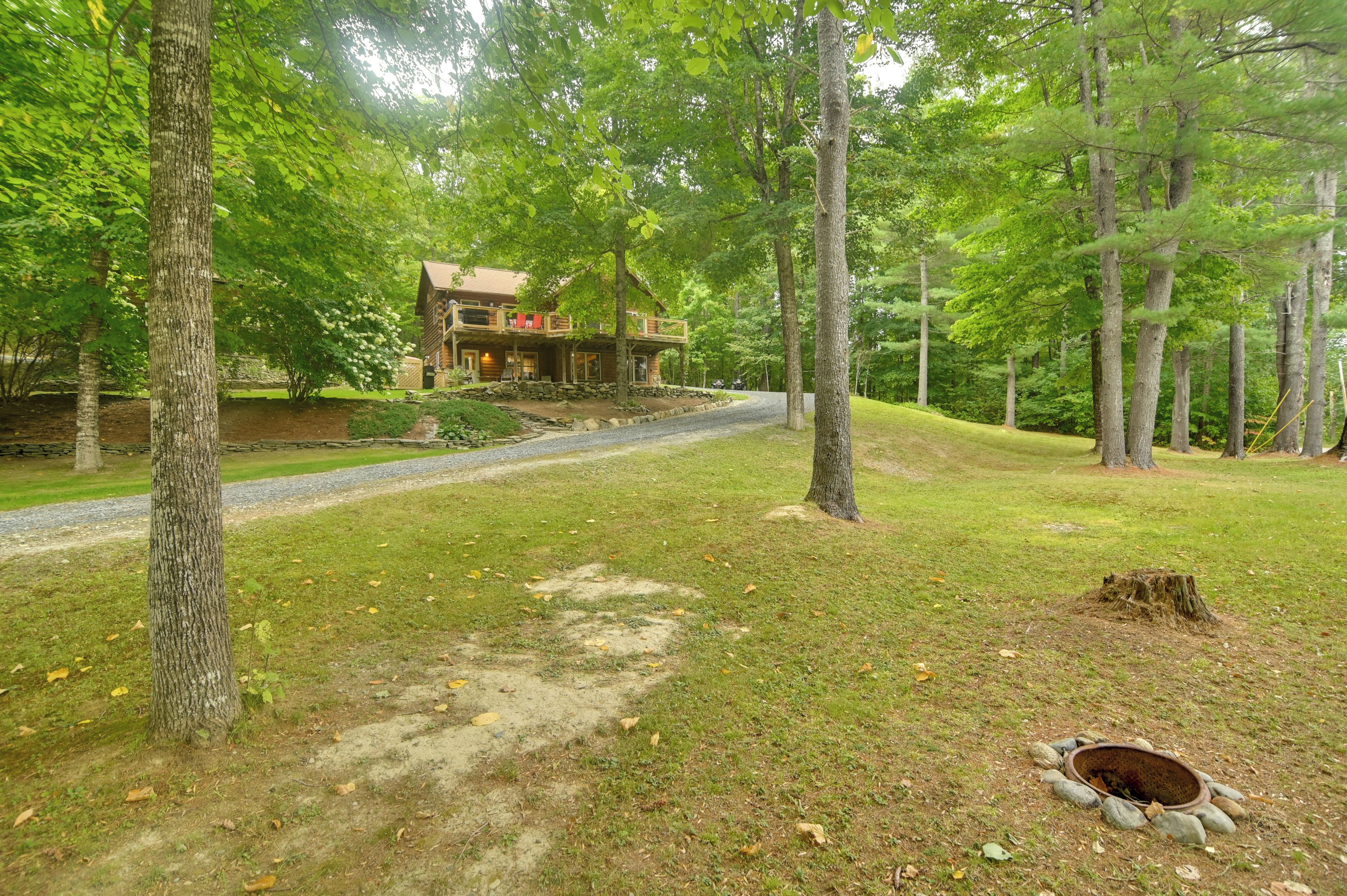 A lodge with a stone foundation, wooden deck, and a covered porch.