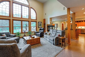 A spacious living room with large windows, a fireplace, and a view of the outdoors. - Spacious Executive Home on Over 11 Private Acres (Rockford)