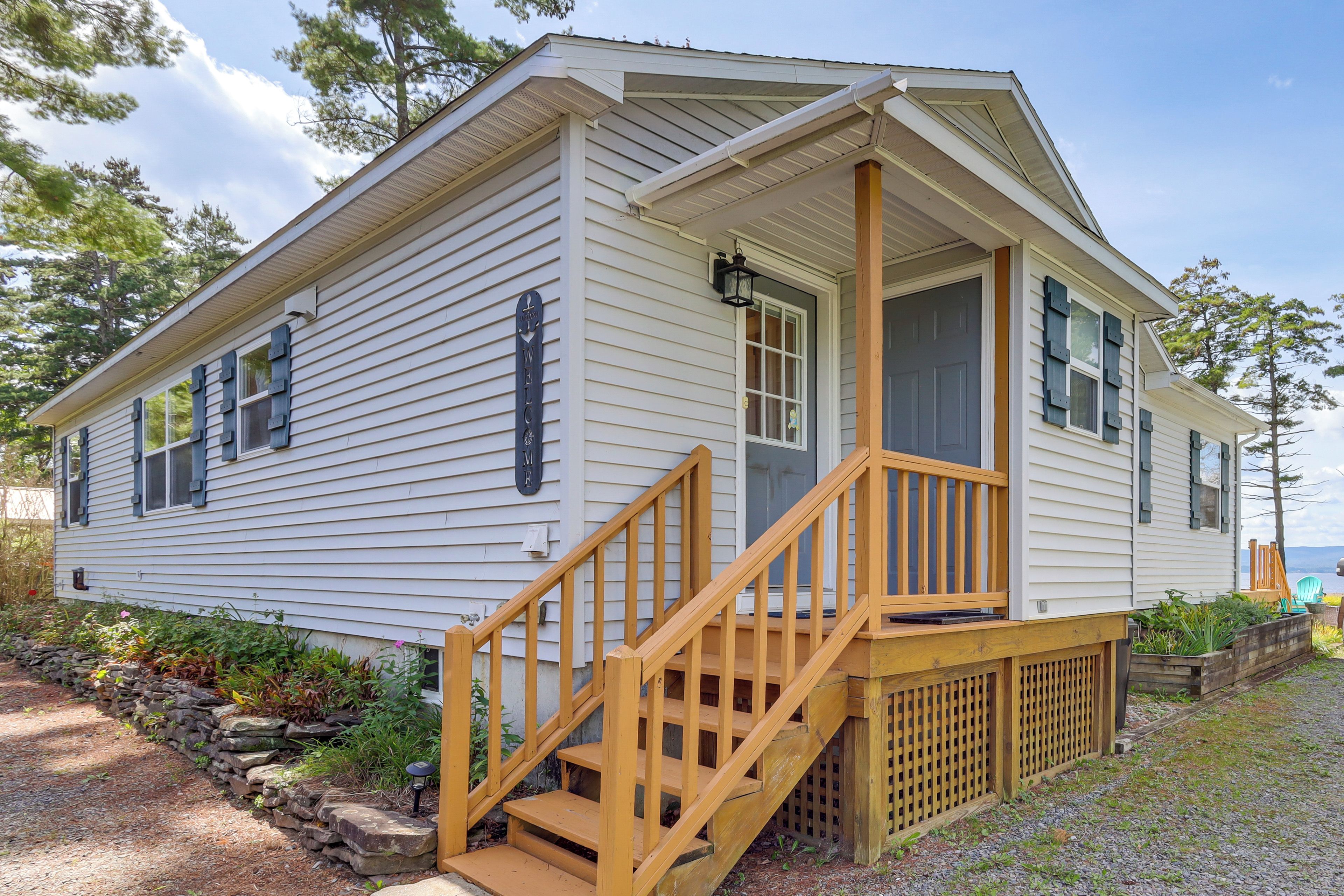 A single-story mobile home with a front porch and wooden steps.