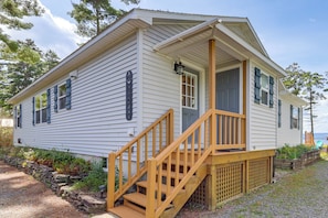 A single-story mobile home with a front porch and wooden steps.