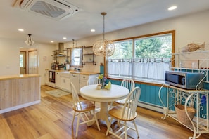 A kitchen with wooden cabinets, a round dining table, and chairs.