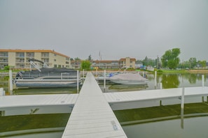 A marina with docked boats, a wooden pier, and buildings in the background. - Lakefront Studio, 3 Mi to Petoskey State Park! (Conway)