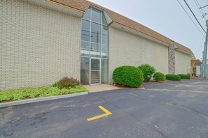 A building with a brick facade, a glass entrance, and a parking lot with yellow directional arrows. - Lakefront Studio, 3 Mi to Petoskey State Park! (Conway)