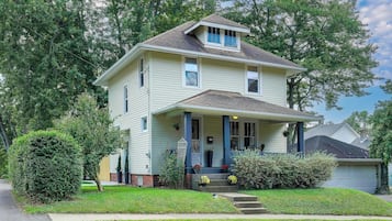 A two-story house with a front porch, a garage, and a well-maintained lawn.