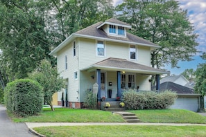 A two-story house with a front porch, a garage, and a well-maintained lawn.