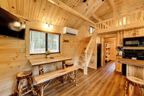 A wooden cabin interior with a kitchen, dining area, and a staircase. - Hike, Bike & Stargaze! Oxford Cabin w/ Fire Pit (Oxford)