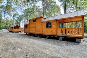 A wooden cabin with a balcony, set in a forested area. - Hike, Bike & Stargaze! Oxford Cabin w/ Fire Pit (Oxford)
