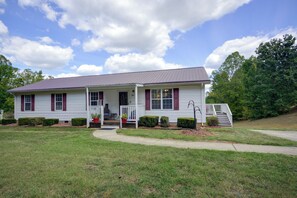 A two-story house with a porch, a front yard, and a driveway.