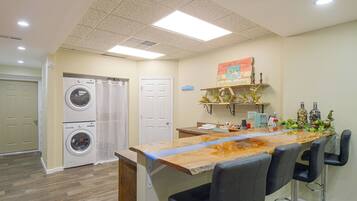 A laundry room with two washing machines, a door, and a ceiling with recessed lighting.