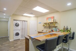 Una sala de bugaderia amb dues rentadores, una porta i un sostre amb il·luminació empotrada.