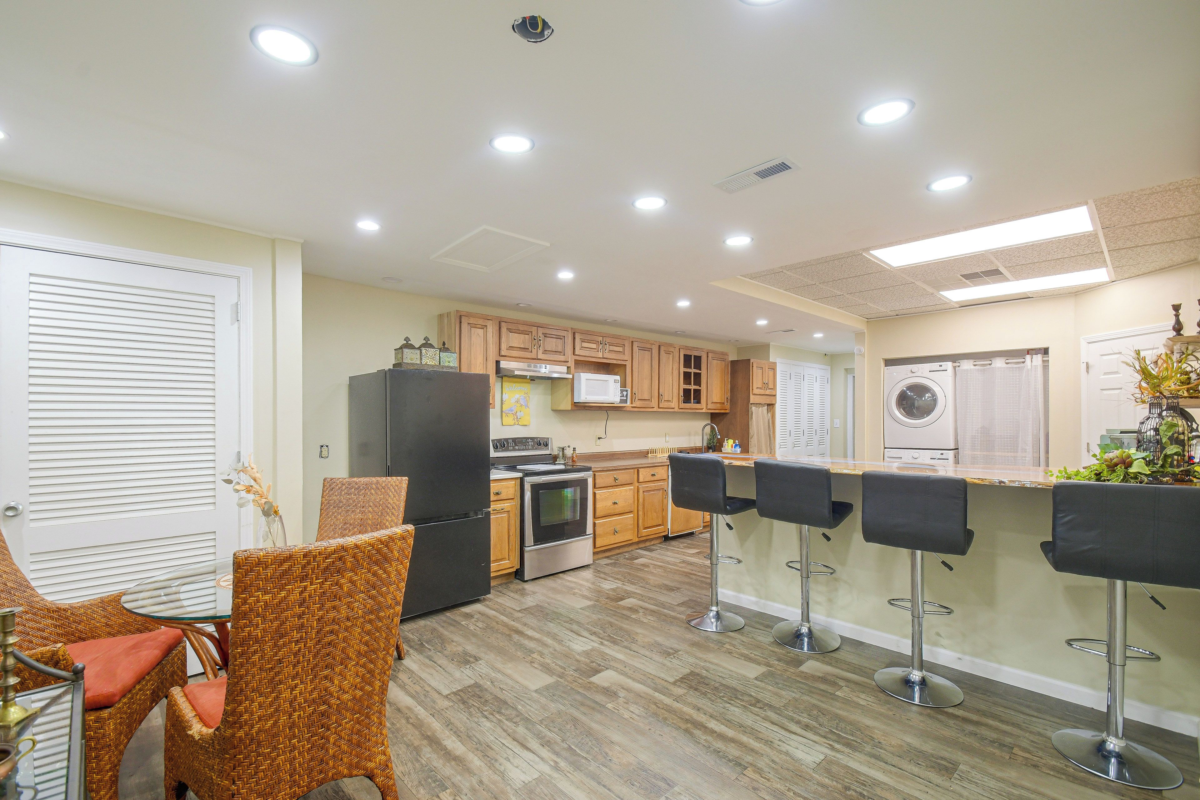 A modern kitchen with wooden cabinets, a stainless steel refrigerator, and a built-in oven.