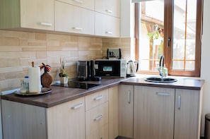 A modern kitchen with a built-in microwave, a coffee maker, and a sink.