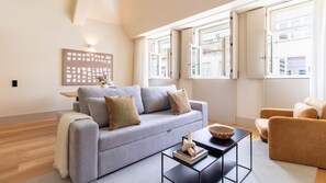 Un soggiorno moderno con un divano grigio, un tavolino da caffè e una poltrona beige.