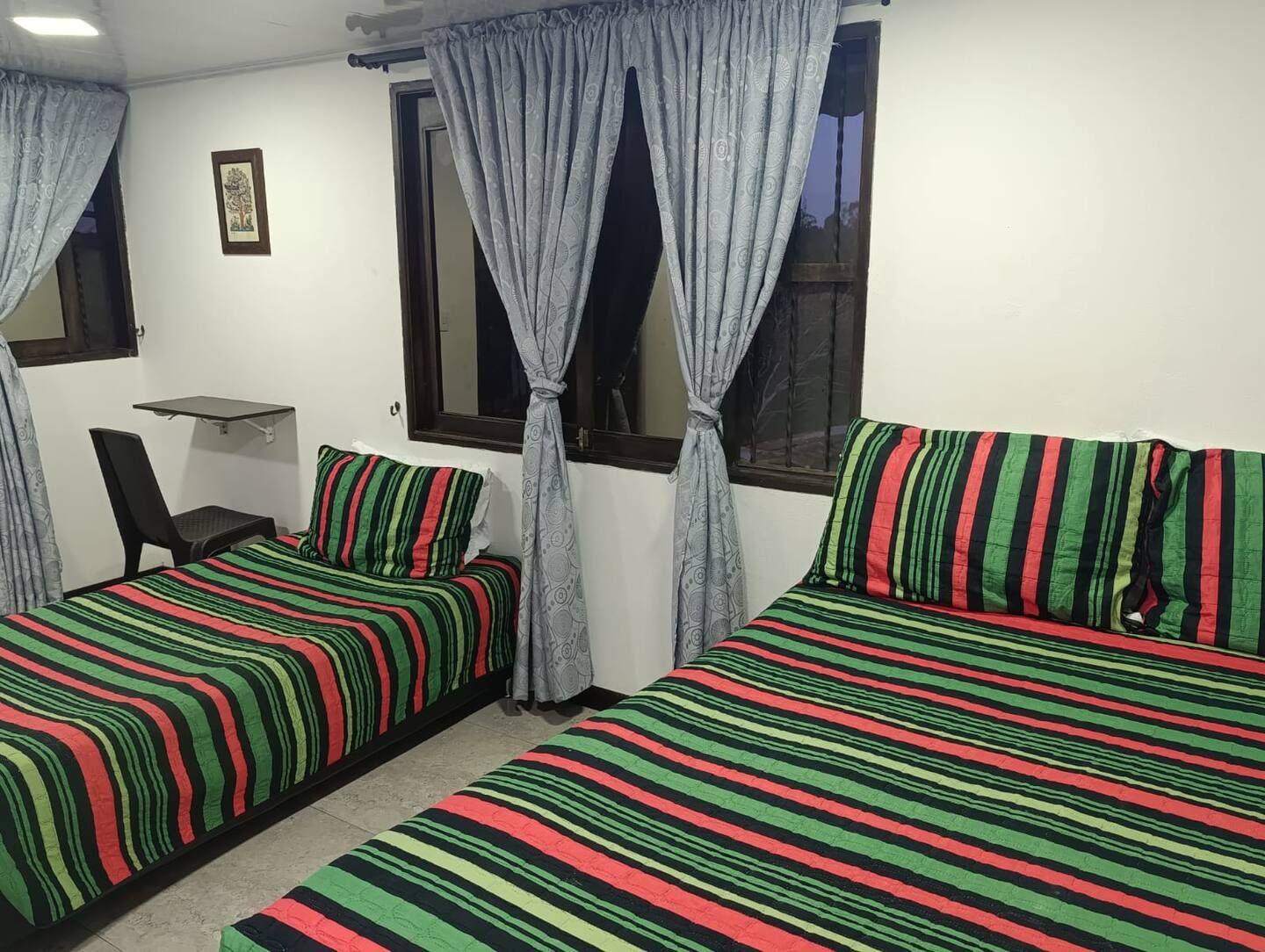 Una habitación con dos camas, un escritorio y una silla.