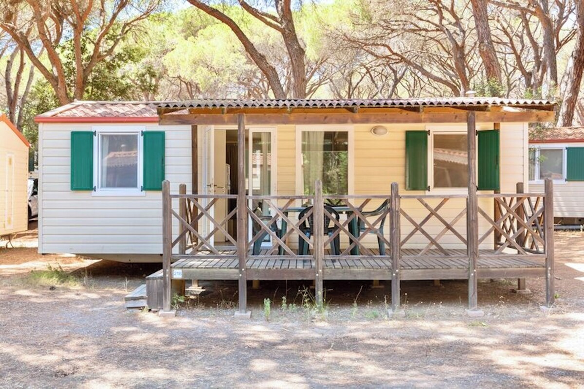 Ein Mobilheim mit Veranda und überdachter Terrasse.