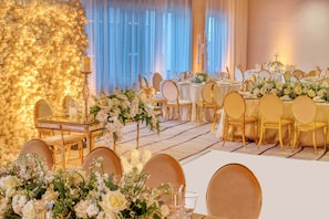 A banquet hall with round tables, gold chairs, and floral centerpieces. - Luxury Downtown Miami Condo w Pool & Views (Miami)