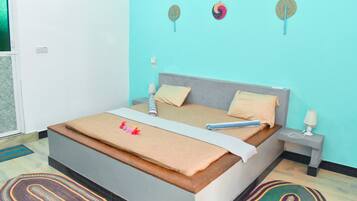 Un dormitorio con cama, mesitas de noche, lámpara y una lámpara fijada a la pared.